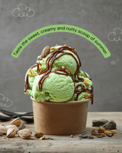 A cup of green pistachio ice cream topped with nuts and caramel, surrounded by pistachios and chocolate pieces on a rustic table.